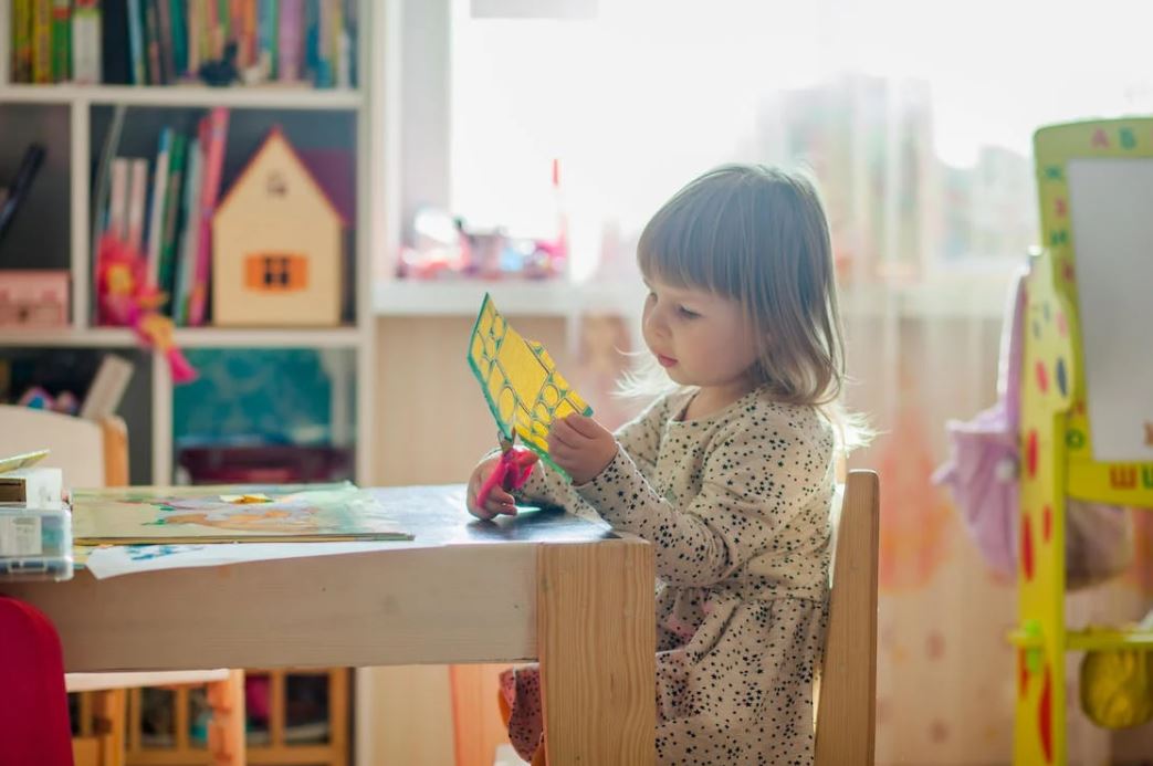 young girl cutting paper
