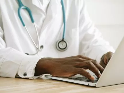Doctor typing on laptop